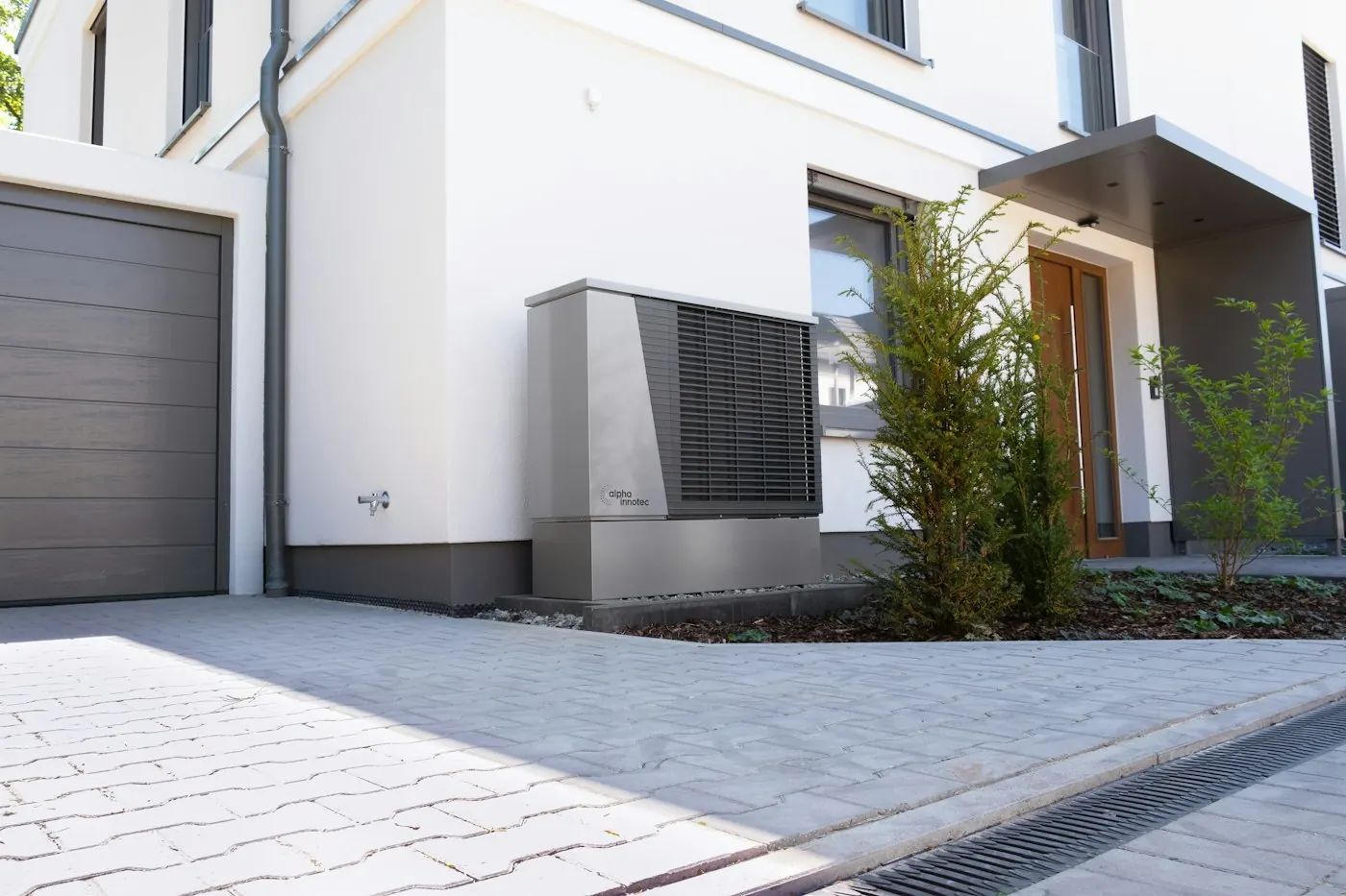 Pompe à chaleur extérieure installée devant une maison individuelle moderne