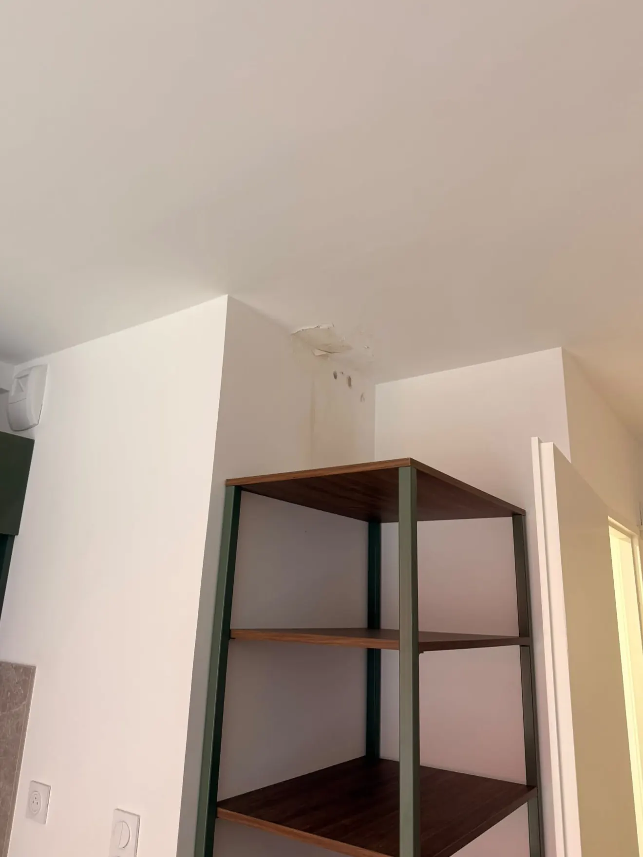 Avant : plafond et angle de mur tachés et cloqués par un dégât des eaux
